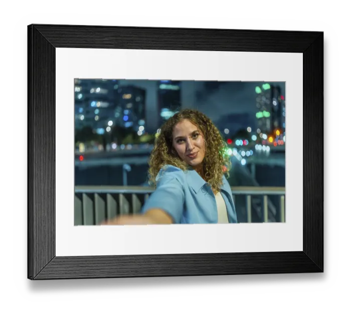 Framed Print : Young woman with curly hair extending her arm to take a selfie Framed Print : Young woman with curly hair extending her arm to take a selfie