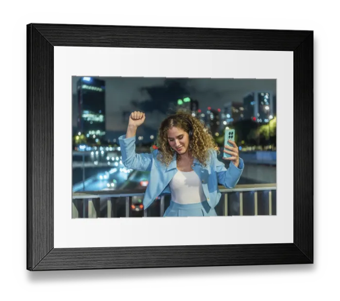 Framed Print : Young woman with curly hair enjoying music through headphones