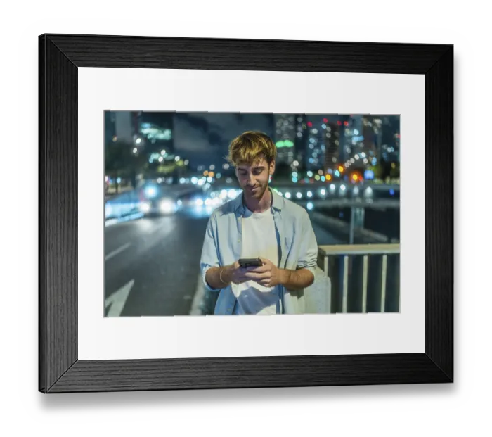 Framed Print : Young man standing on a city bridge at night Framed Print : Young man standing on a city bridge at night