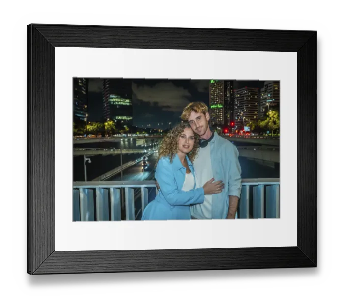Framed Print : Young couple embracing on an urban bridge at night