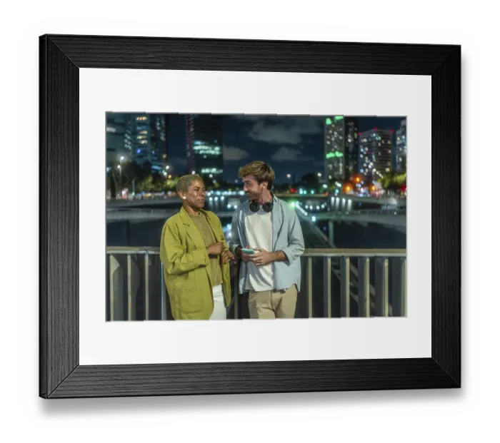 Framed Print : Diverse young couple chatting and smiling on an urban bridge at night
