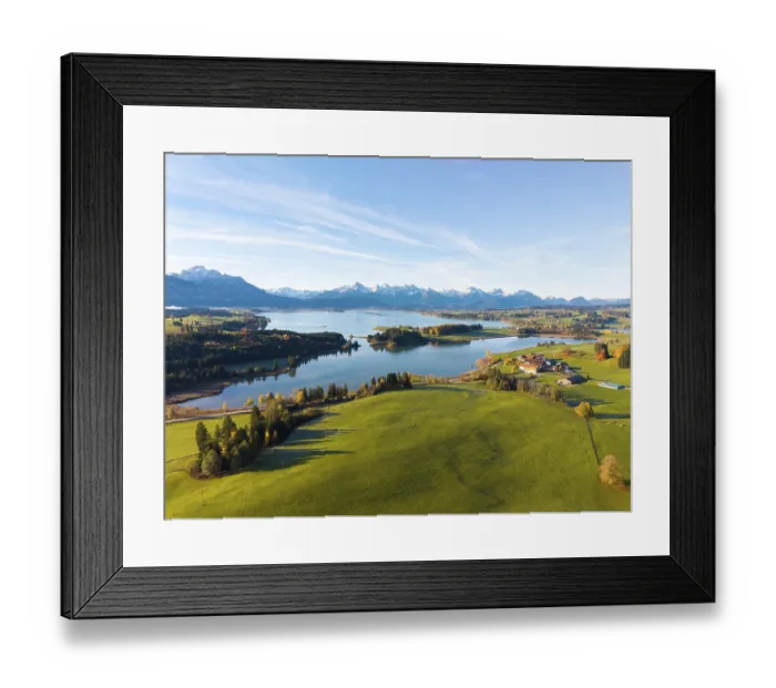 Framed Print : View of a lake surrounded by green hills and mountains under a clear blue sky