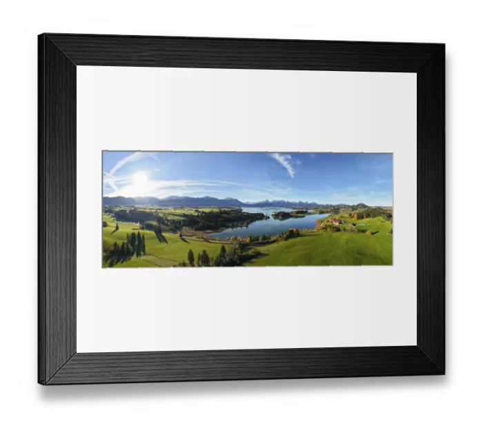 Framed Print : Wide panoramic view of a green landscape with lake and mountain backdrop under clear sky Framed Print : Wide panoramic view of a green landscape with lake and mountain backdrop under clear sky