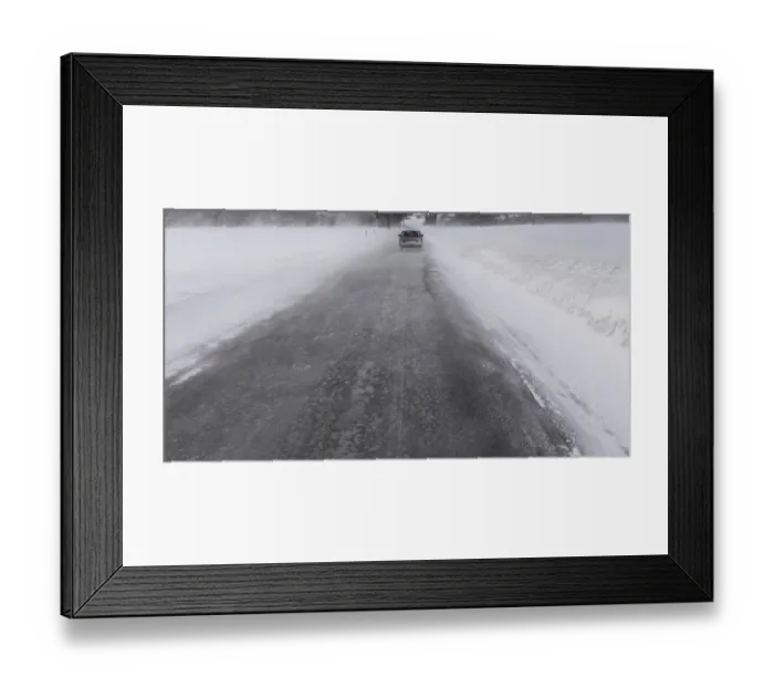 Framed Print : Car driving away in winter blizzard on a narrow snowy road in Norway
