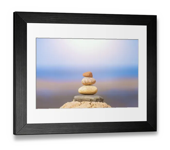 Framed Print : Zen balanced small pile of stacked stones on the beach in summer