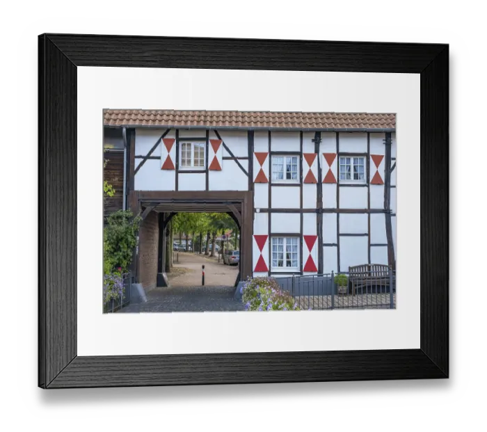 Framed Print : A half-timbered house with red brick detail and a large archway Framed Print : A half-timbered house with red brick detail and a large archway