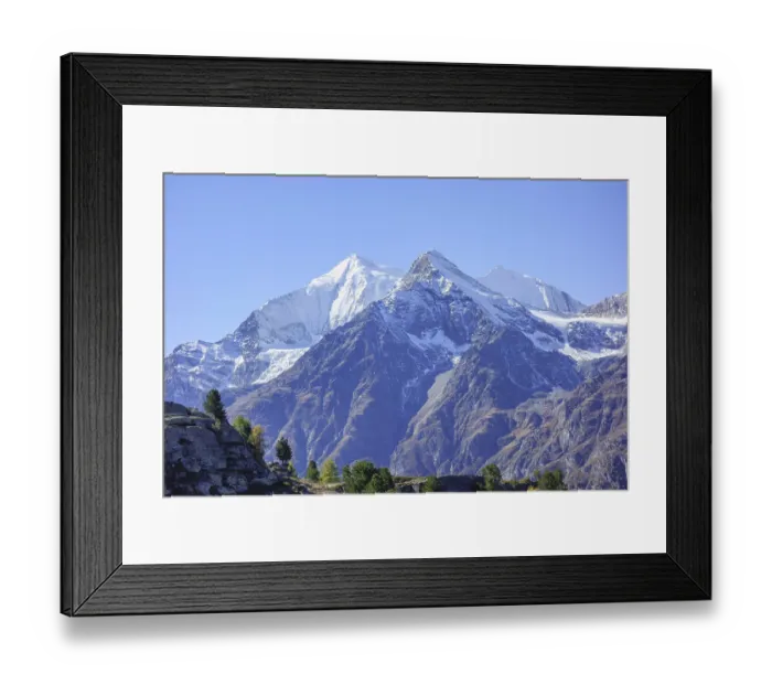 Framed Print : Snowy mountain peaks with rocks and clear sky