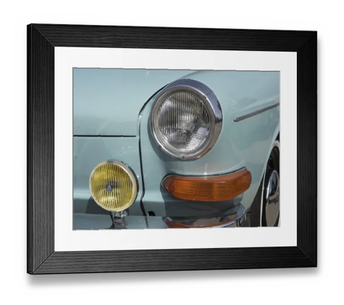 Framed Print : Front view of a turquoise vintage car with additional yellow headlights and chrome details