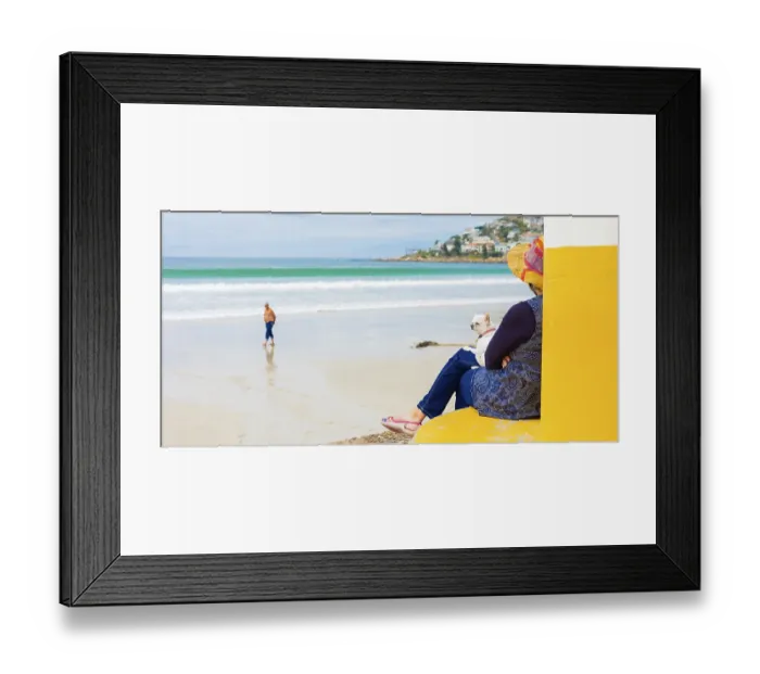 Framed Print : Elderly woman sitting by a beach with a dog on her lap Framed Print : Elderly woman sitting by a beach with a dog on her lap