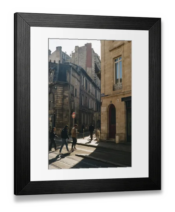 Framed Print : People walking along tram tracks in a sunlit street with classic architecture Framed Print : People walking along tram tracks in a sunlit street with classic architecture