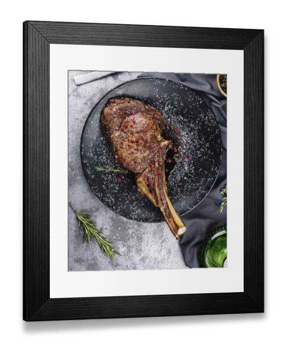 Framed Print : Food, Grilled pork steak with bone in sauce on black plate Framed Print : Food, Grilled pork steak with bone in sauce on black plate