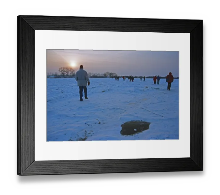 Framed Print : People walk across ice rink, sunset