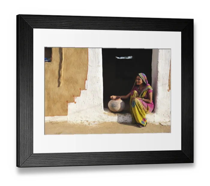 Framed Print : Young woman with water jug at the entrance to her house