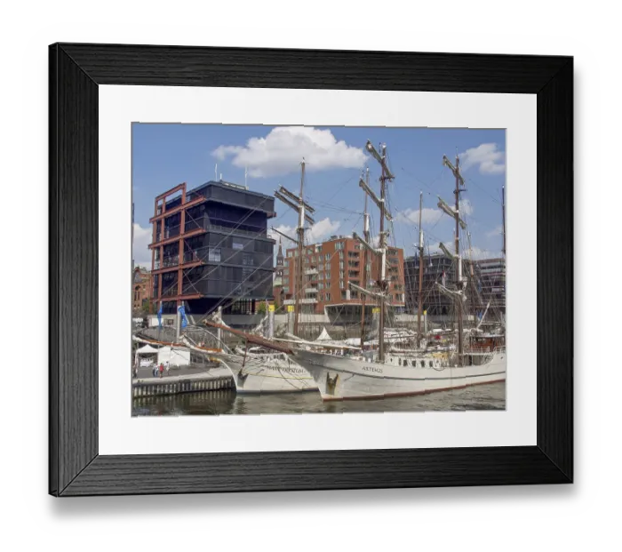 Framed Print : Historic sailing ships in the harbor in front of modern city architecture under clear skies