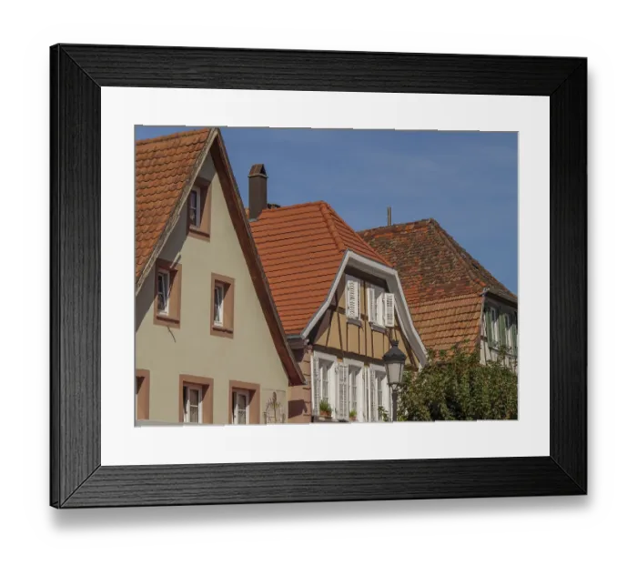 Framed Print : Three half-timbered houses with red tiled roofs and white shutters under a blue sky Framed Print : Three half-timbered houses with red tiled roofs and white shutters under a blue sky