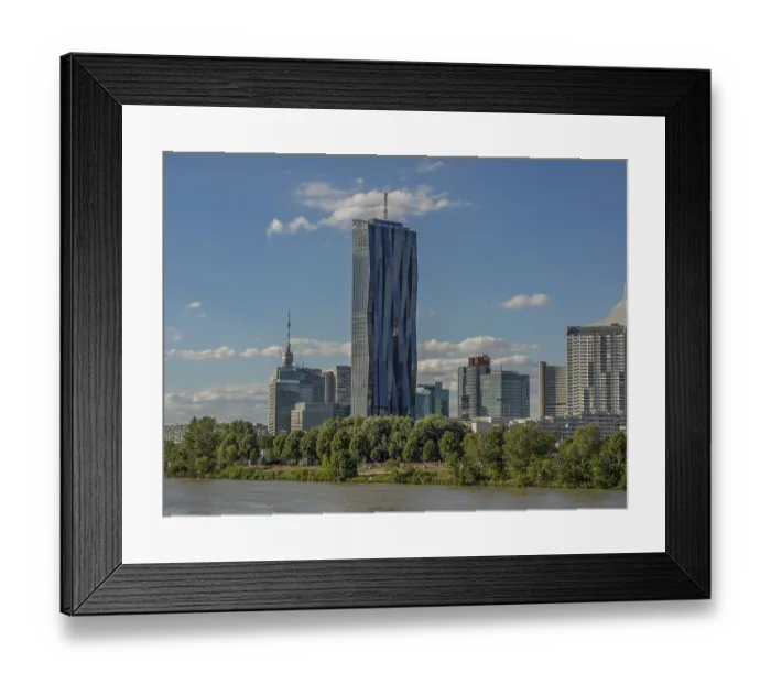 Framed Print : View of DC Tower in a modern skyline under cloudy sky with a river in the foreground