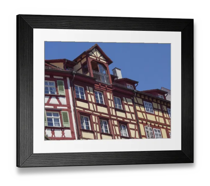 Framed Print : Traditional half-timbered house with red and yellow elements against a blue sky