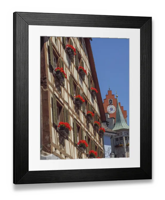 Framed Print : Medieval half-timbered house with lush flowers under clock tower