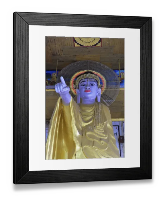 Framed Print : Large Buddha statue in golden robe with glowing halo and extended finger