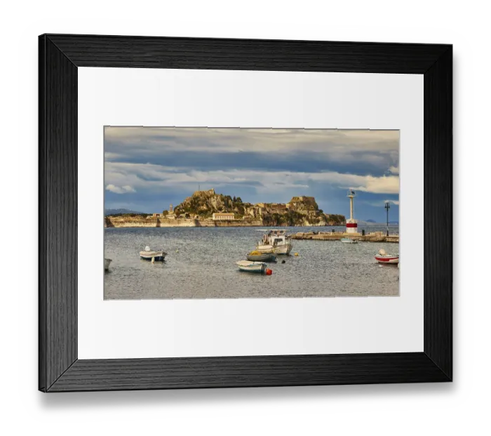Framed Print : View of an island with fortress and small boats in the water under cloudy sky