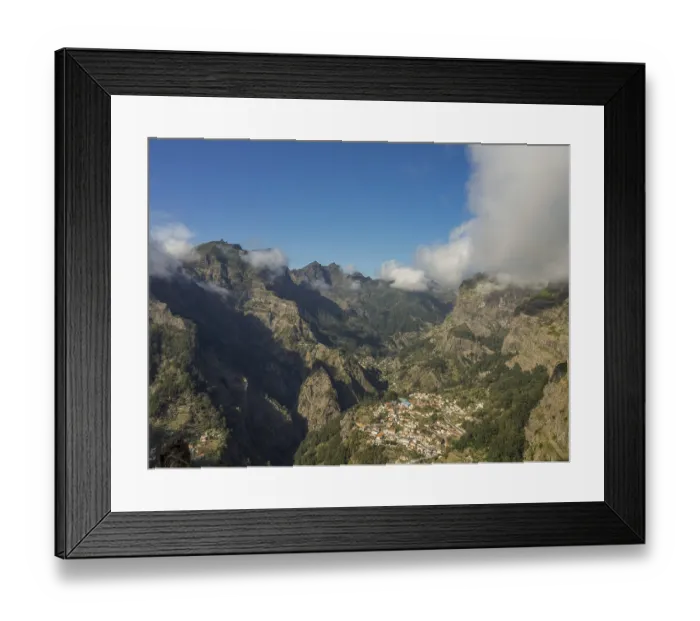 Framed Print : Village nestled in a valley surrounded by high mountains and clouds Framed Print : Village nestled in a valley surrounded by high mountains and clouds
