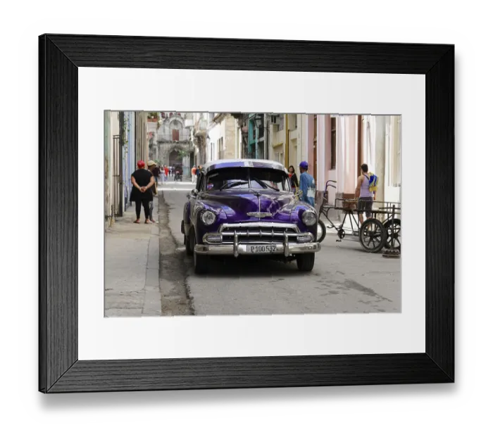 Framed Print : Old classic car parked in a busy street with colonial architecture