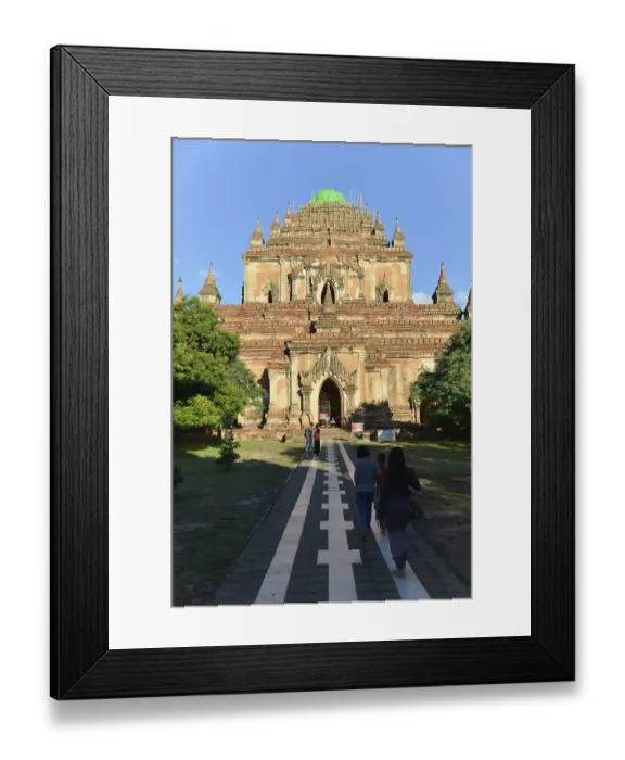Framed Print : Visitors walk along a paved path that leads to a large temple