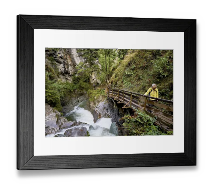 Framed Print : Female hiker standing on wooden walkway