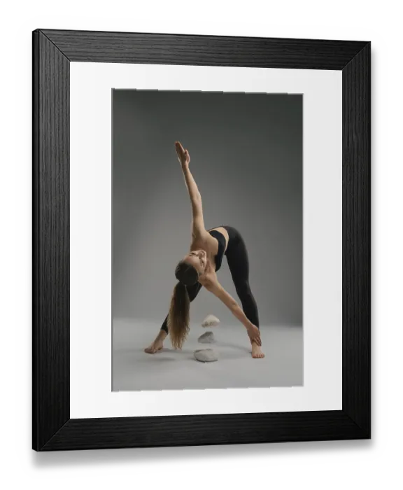 Framed Print : A woman performs a yoga pose, stretching her body to the side while balancing on one leg Framed Print : A woman performs a yoga pose, stretching her body to the side while balancing on one leg
