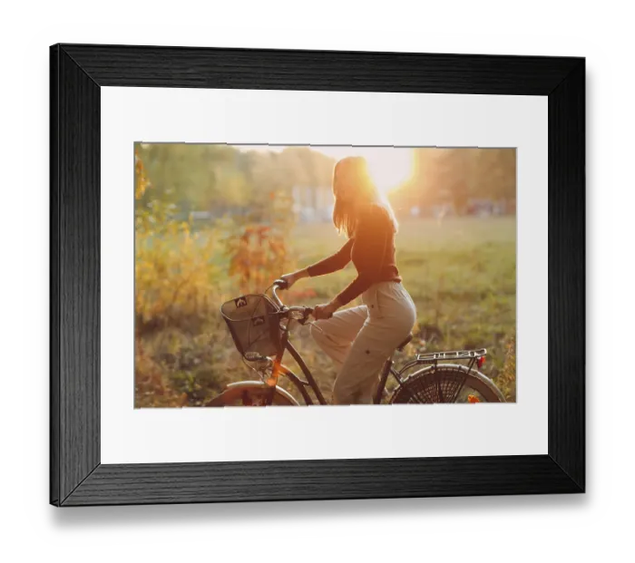 Framed Print : Happy active young woman riding vintage bicycle in autumn park at sunset