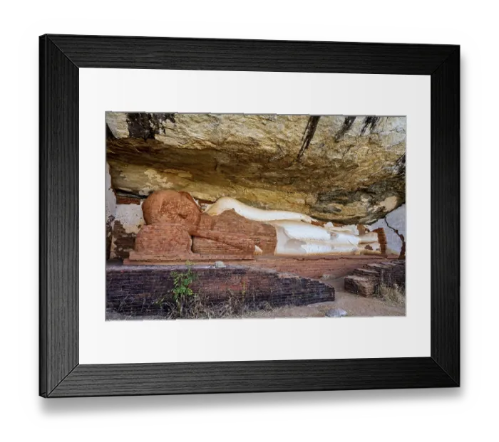 Framed Print : Ancient sandstone sculpture of a Buddha reclining under a rocky outcrop