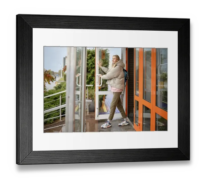 Framed Print : A woman steps out of a contemporary building on a cool day Framed Print : A woman steps out of a contemporary building on a cool day