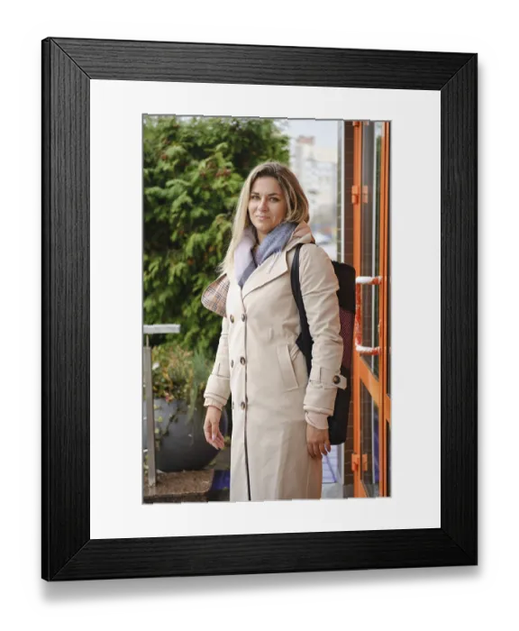 Framed Print : A woman stands outside a contemporary building Framed Print : A woman stands outside a contemporary building