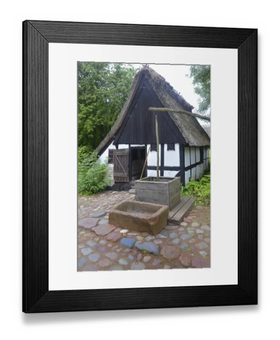 Framed Print : Older half-timbered house with thatched roof by older well in Den gamle by