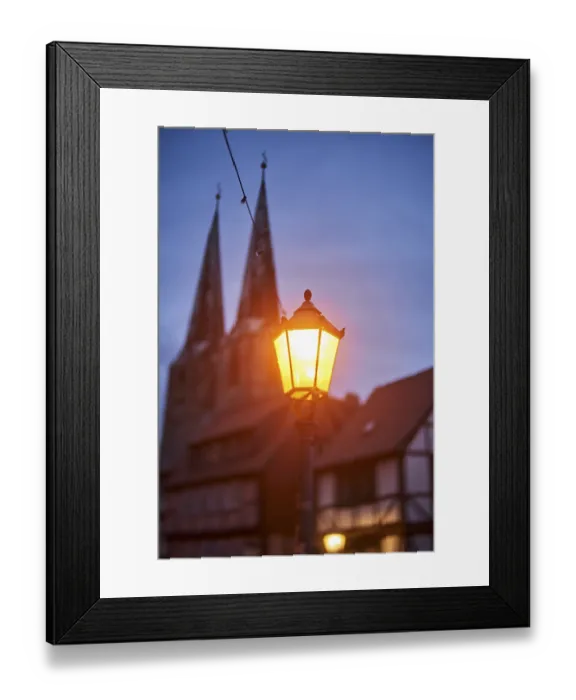 Framed Print : Nocturnal street lamp glows in the dark blue hour in front of St