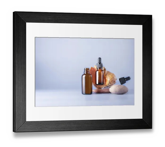 Framed Print : Two glass brown bottles with a pipette for a cosmetic product with a sea shell on stones Framed Print : Two glass brown bottles with a pipette for a cosmetic product with a sea shell on stones