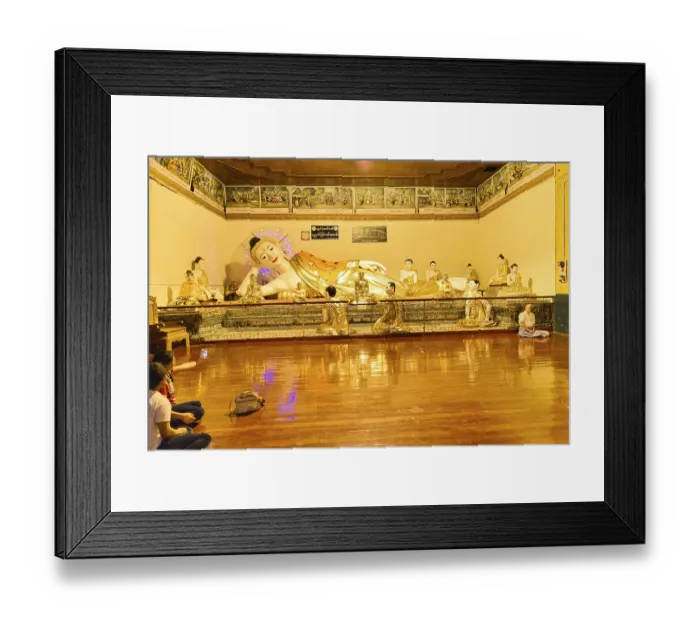 Framed Print : Resting Buddha statue in a gold-decorated interior with meditation participants