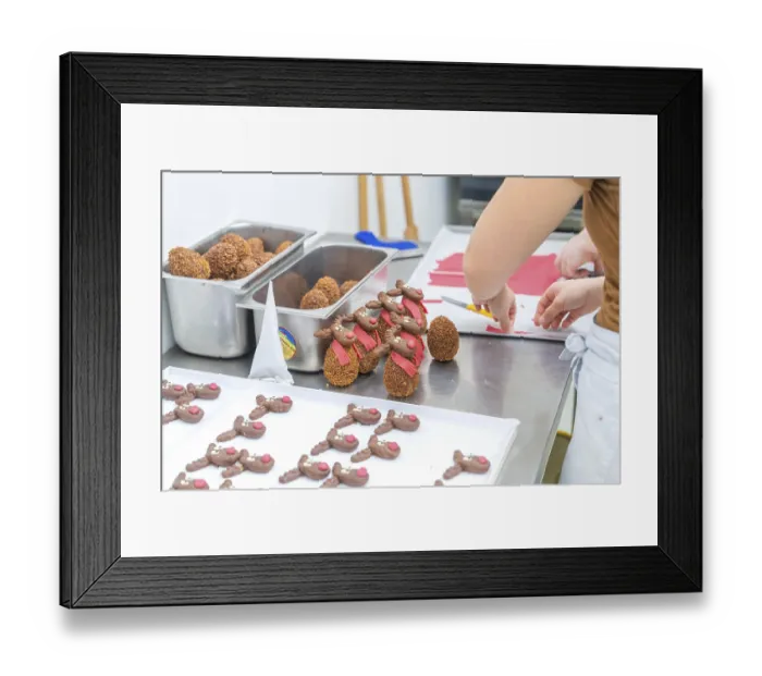 Framed Print : Chocolate brown reindeer cookies with red scarves are prepared in a bakery Framed Print : Chocolate brown reindeer cookies with red scarves are prepared in a bakery