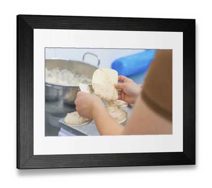 Framed Print : Two hands working with a dough and a silicone spatula on a kitchen table