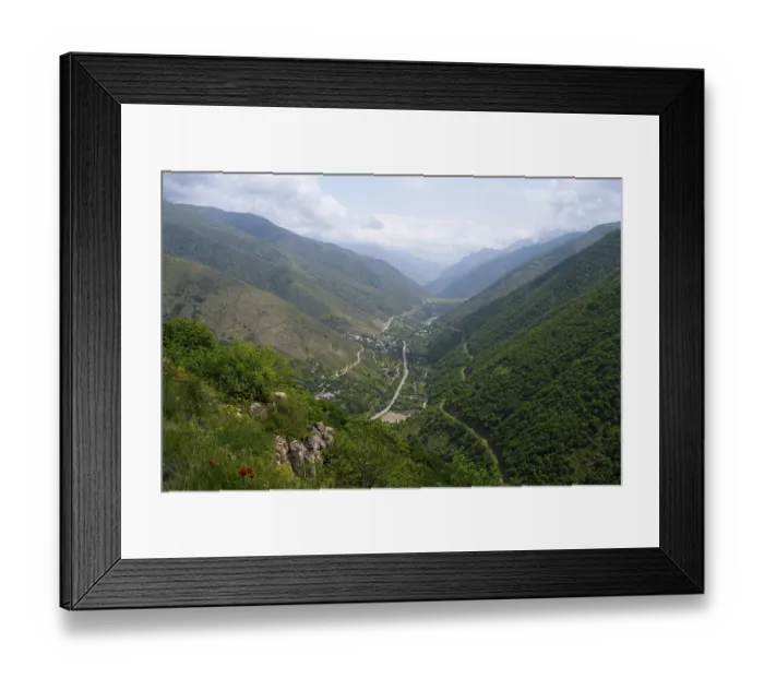 Framed Print : Extensive mountain landscape with a river surrounded by lush vegetation and clouds in the sky Framed Print : Extensive mountain landscape with a river surrounded by lush vegetation and clouds in the sky