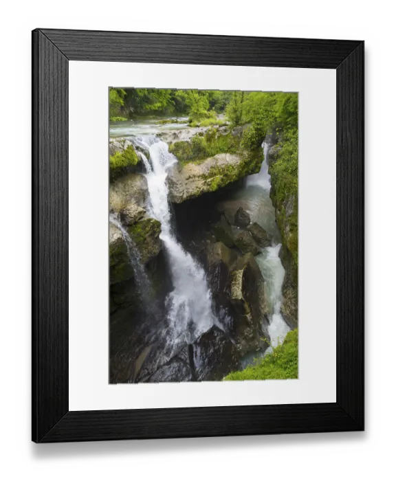 Framed Print : Narrow waterfall through deep gorge surrounded by thick greenery