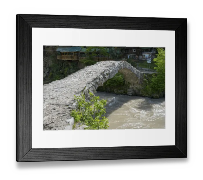 Framed Print : Historic stone bridge crosses bubbling river in forest