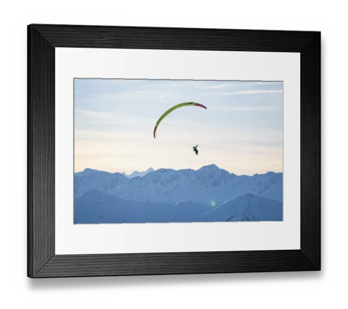 Framed Print : Paragliders flying over snowy mountain peaks in winter in evening light Framed Print : Paragliders flying over snowy mountain peaks in winter in evening light