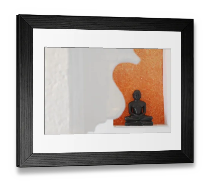 Framed Print : Statue of a black Buddha sitting meditating against an orange background