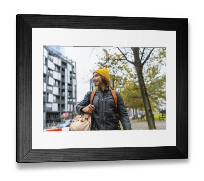 Framed Print : Young man with a yellow beanie and black leather jacket carrying a duffel bag and backpack Framed Print : Young man with a yellow beanie and black leather jacket carrying a duffel bag and backpack