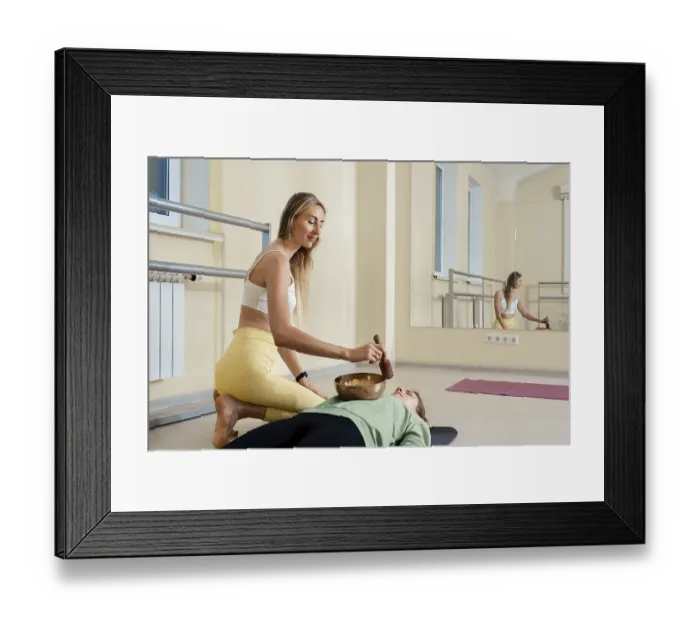 Framed Print : A yoga instructor assists a student in a serene studio setting