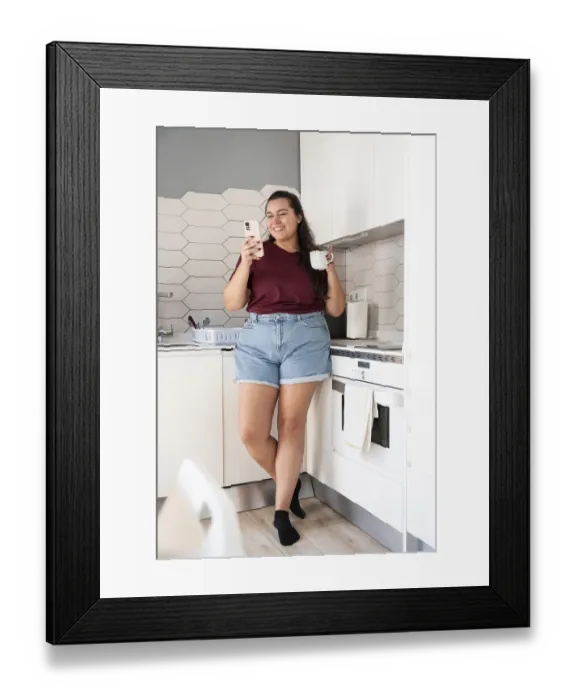 Framed Print : A curvy woman in casual clothes stands in a bright kitchen
