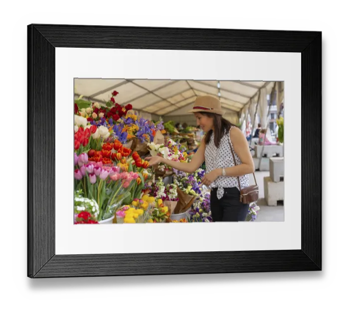 Framed Print : A pretty tourist with a photo camera visiting a flower market