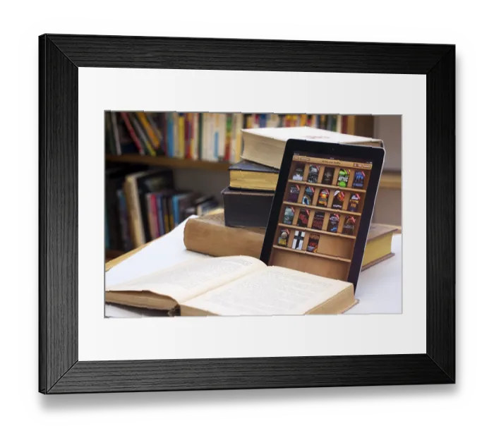 Framed Print : E-book reader beside a stack of old books, Germany