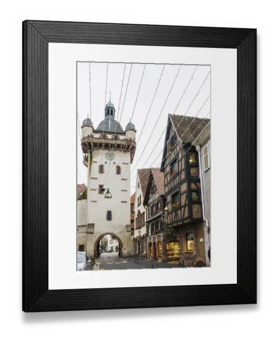 Framed Print : Clock tower and artfully painted half-timbered houses